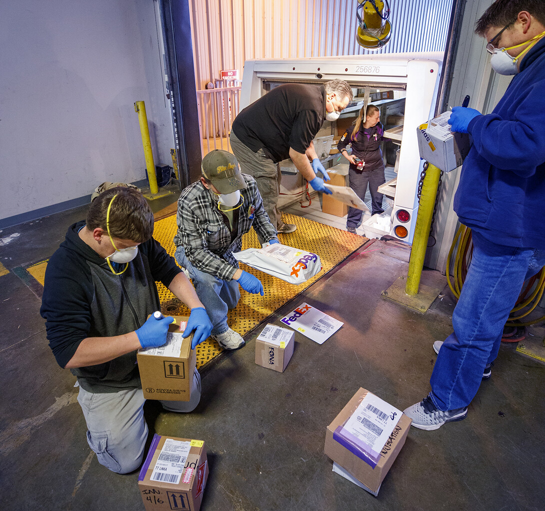 University employees sort packages after a morning delivery at the Facilities Management Shops on N. 22nd St. The facility has been set up to serve as a central distribution point for the majority of packages delivered to campus during the COVID-19 pandemic.