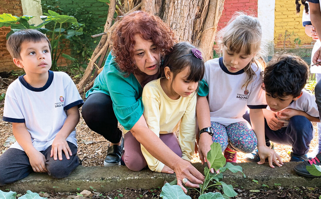 Teacher Elizinete Natália Queiroz de Araújo Souza, second from left, explores the garden with her young students at EMEI Ignacio in Recife, Brazil, one of the preschools engaged in the PreSTAR pilot impact project. (Photo by Dana Ludvik, CYFS)