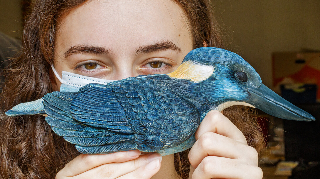 Kinga Aletto, a junior in College of Agricultural Sciences and Natural Resources, holds her life-sized clay model of the Javan blue-banded kingfisher. Creating the model of the critically-endangered bird is part of her UCARE research project.
