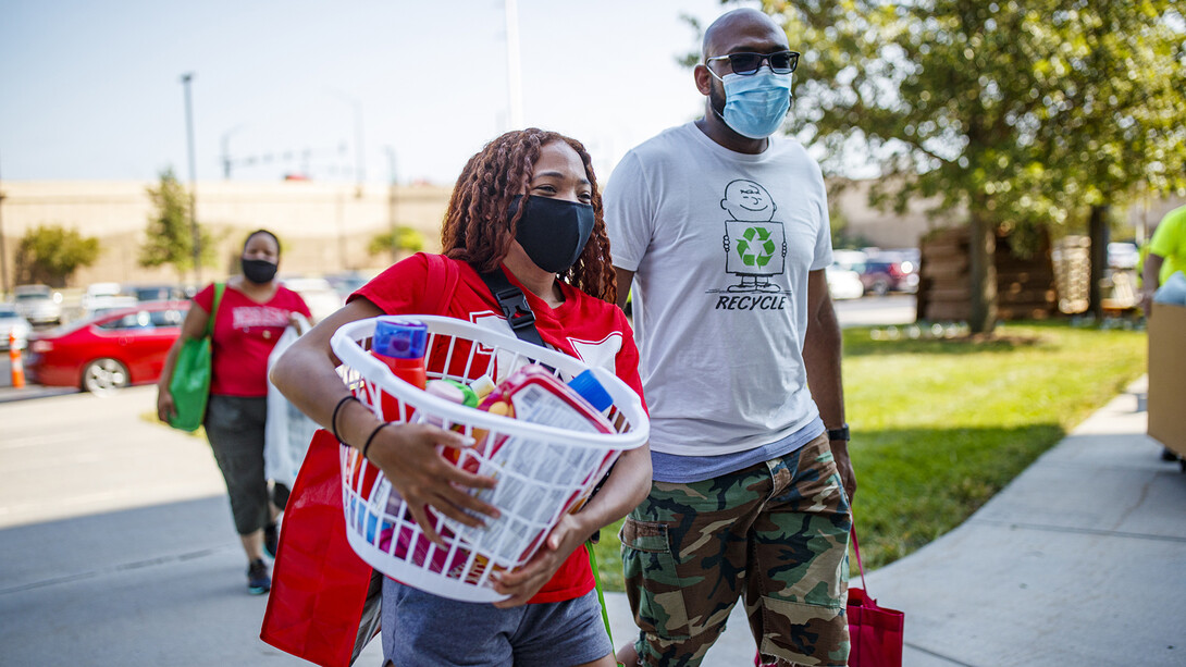 Lauren Lewis, of Omaha, carries in the last items for her Harper Hall room.