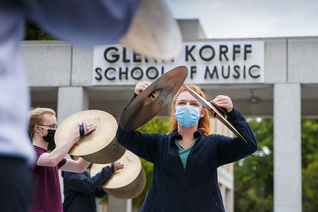 Cymbal practice comes to a crescendo as Caroline Nebel, a senior from Lincoln, and the rest of the section work outside of the Glenn Korff School of Music..