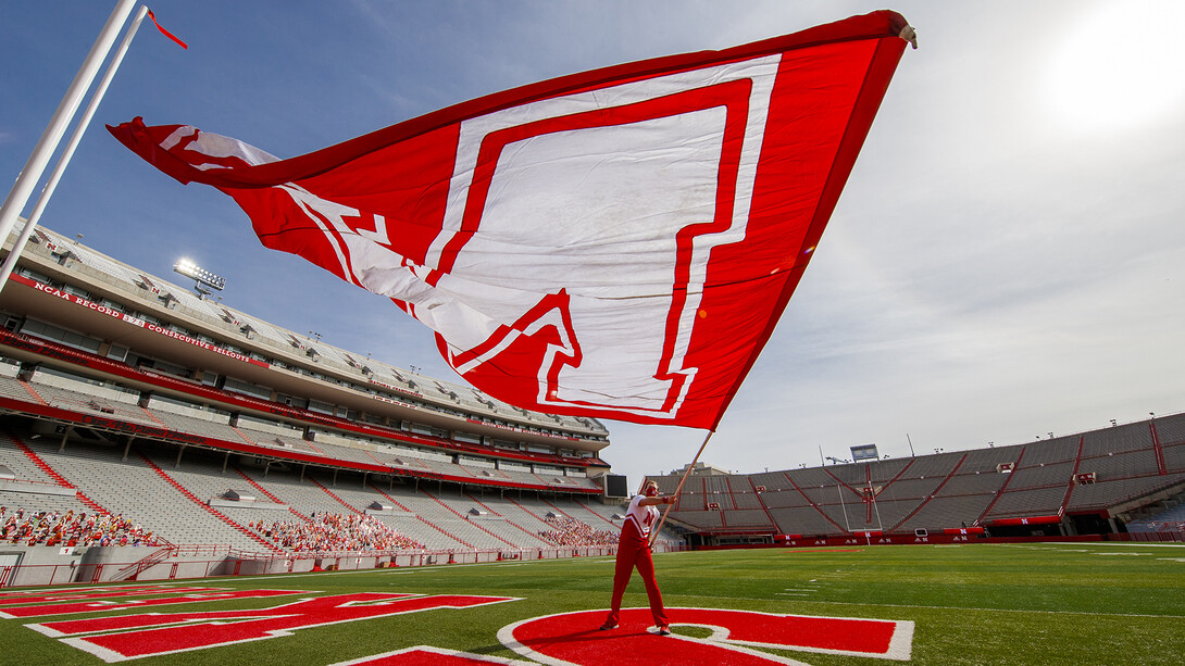 A member of the Husker cheer squad flies an "N" flag in the end zone during a taping event on Oct. 18. HuskerVision has recorded a number of game day experiences and will offer them through Husker football livestream.