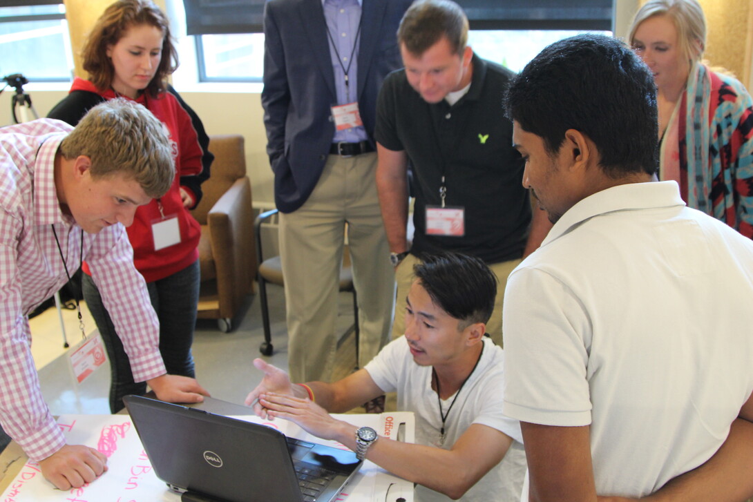  Team members discuss a mobile app business called CornSoyWater during the 3DS Engler Startup Experience.