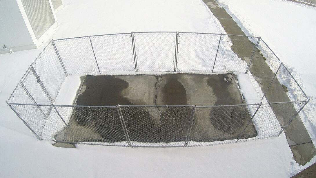 A slab of conductive concrete demonstrates its de-icing capability outside the Peter Kiewit Institute in Omaha during a winter storm in December 2015. The concrete carries just enough current to melt ice while remaining safe to the touch.