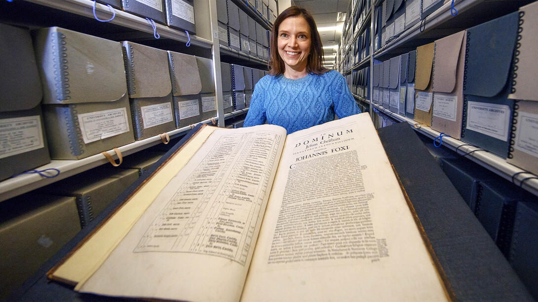 Traci Robison, photo and exhibits specialist with Archives and Special Collections in University Libraries, displays a volume of John Foxe's "Book of Martyrs."