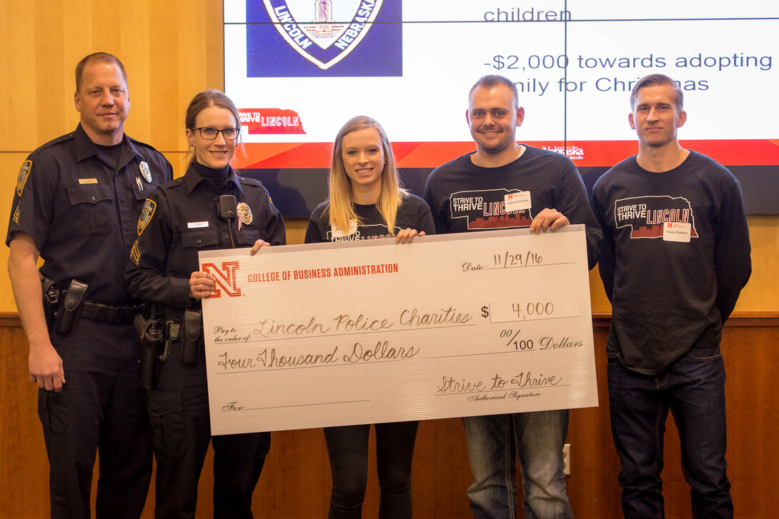 Leading People and Project Management class members present a $4,000 check to the Lincoln Police Department. Pictured (from left) are Officers Chad Barrett and Shannon Karl and students Paxton Barta, Adam Greitens and Nikita Pankins.