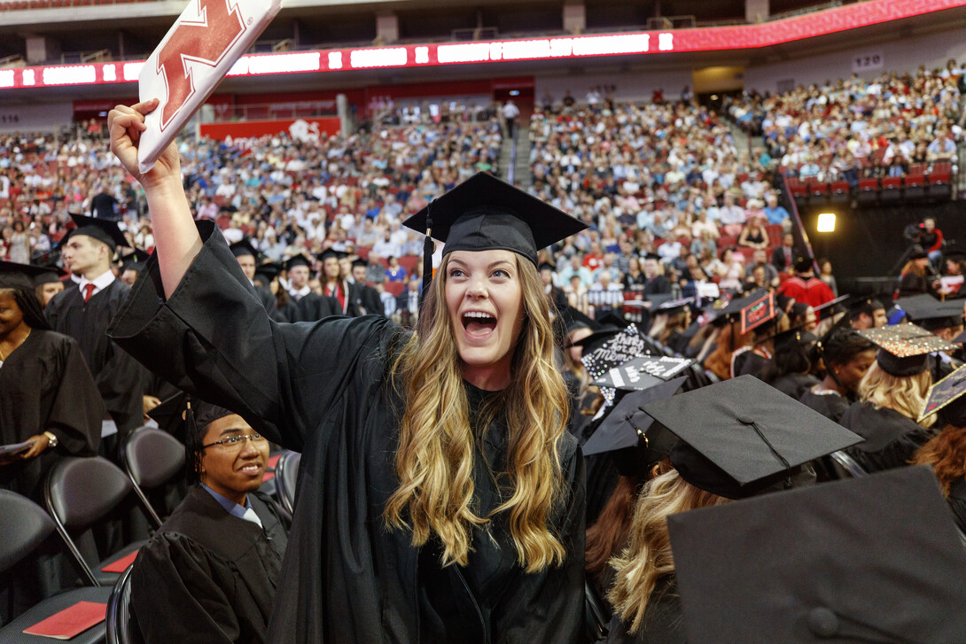 Anne Bachmann shows off her diploma to family and friends. She earned a Bachelor of Science in Business Administration.