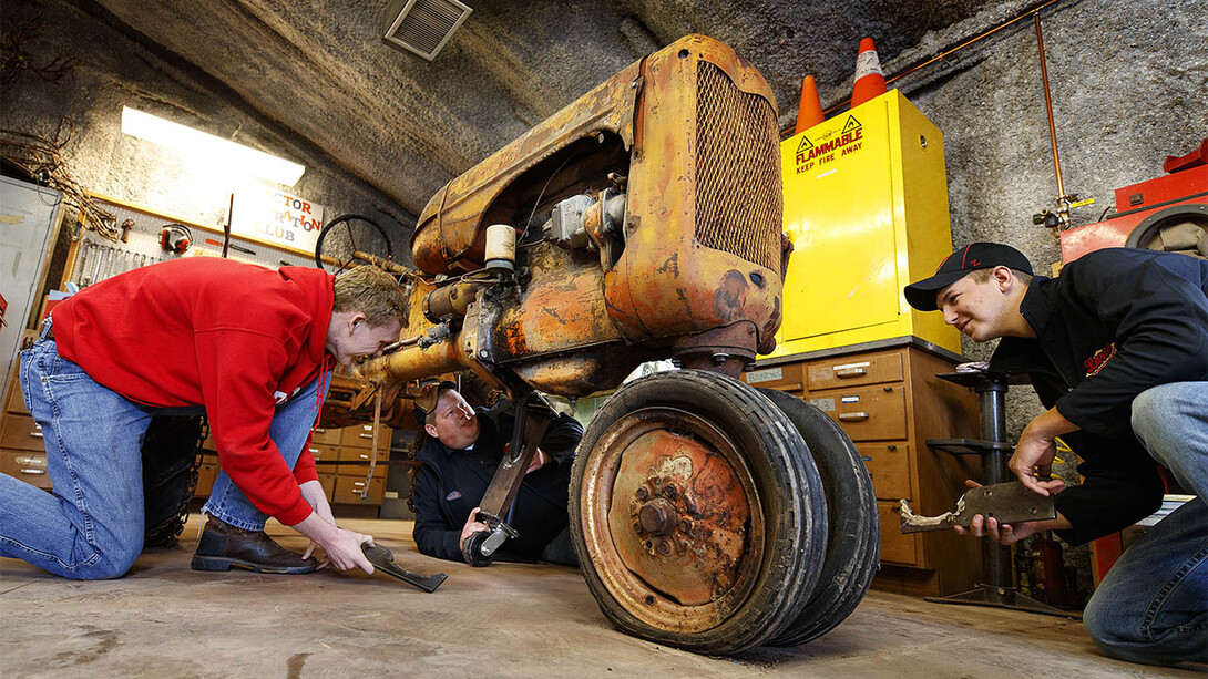 Tractor Restoration Club members (from left) Kiel Kruse, Joshua Bauer and Jaythan Scheideler work with support pieces that will be attached to the 1945 Allis Chalmers Model C so it can be moved around for restoration work. Club members are preparing the tractor for display at the Homestead National Monument of America near Beatrice.