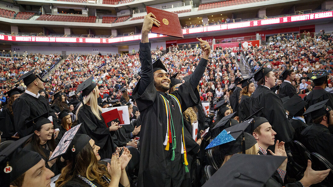 Nadir Al Kharusi shows off his diploma to family and friends during the undergraduate commencement ceremony Dec. 16 at Pinnacle Bank Arena. Al Kharusi stood after Chancellor Ronnie Green asked first-generation college graduates to stand and be recognized. He earned a Bachelor of Arts.