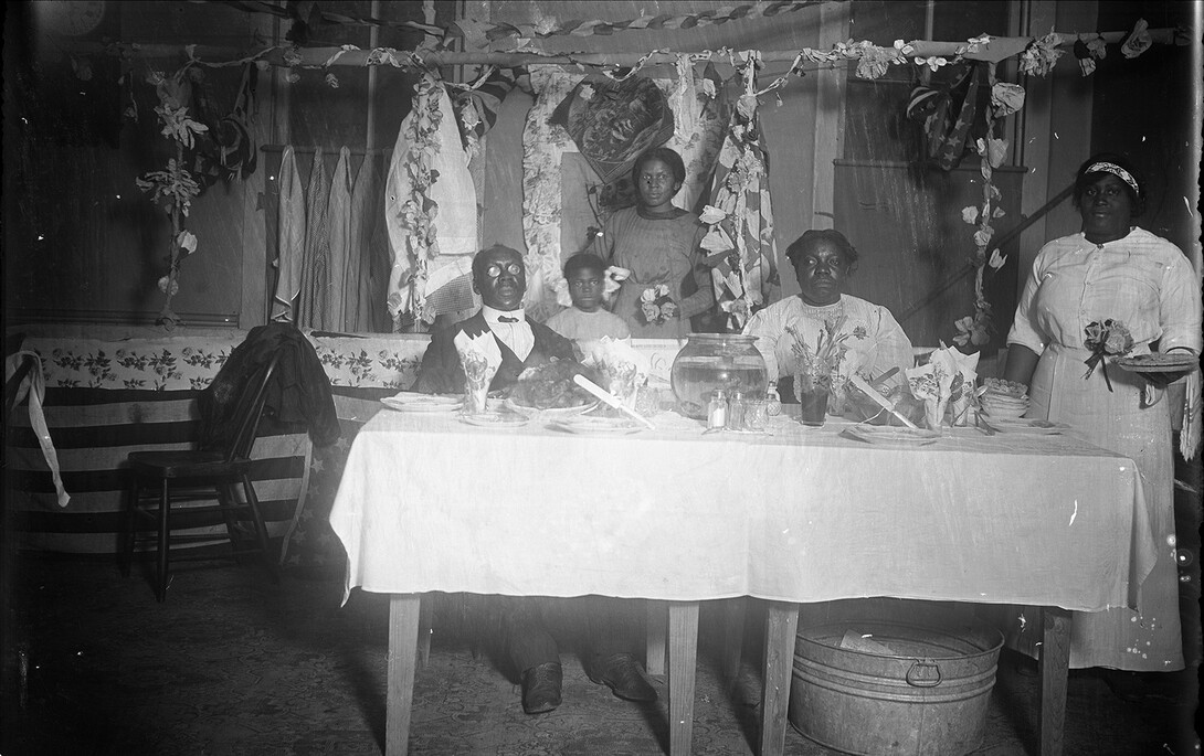 "Untitled (family portrait after a meal)," an undated, black and white photograph from a glass plate negative by John Johnson. The negative is part of the MONA archives collection and was a gift of Library Media Services, Lincoln, Nebraska Public Schools.