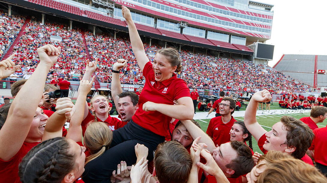 Sophia Kallas of Green Bay, Wisconsin, is held aloft by fellow Cornhusker Marching Band members after winning the “drill down” competition during the 2018 exhibition. The 2019 event is 7 p.m. Aug. 23.