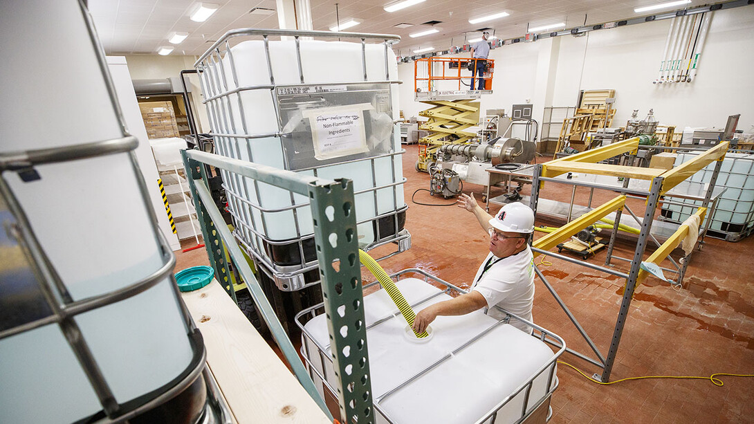 Jan Tenbensel, chairman of the Nebraska Ethanol Board, directs Russell Parde as nonflammable ingredients are mixed inside the Food Innovation Center. The ingredients are mixed with the ethanol under stringent safety rules. Hand sanitizer is being made at Nebraska Innovation Campus through a collaboration between the Food Innovation Center and the Nebraska Ethanol Board.