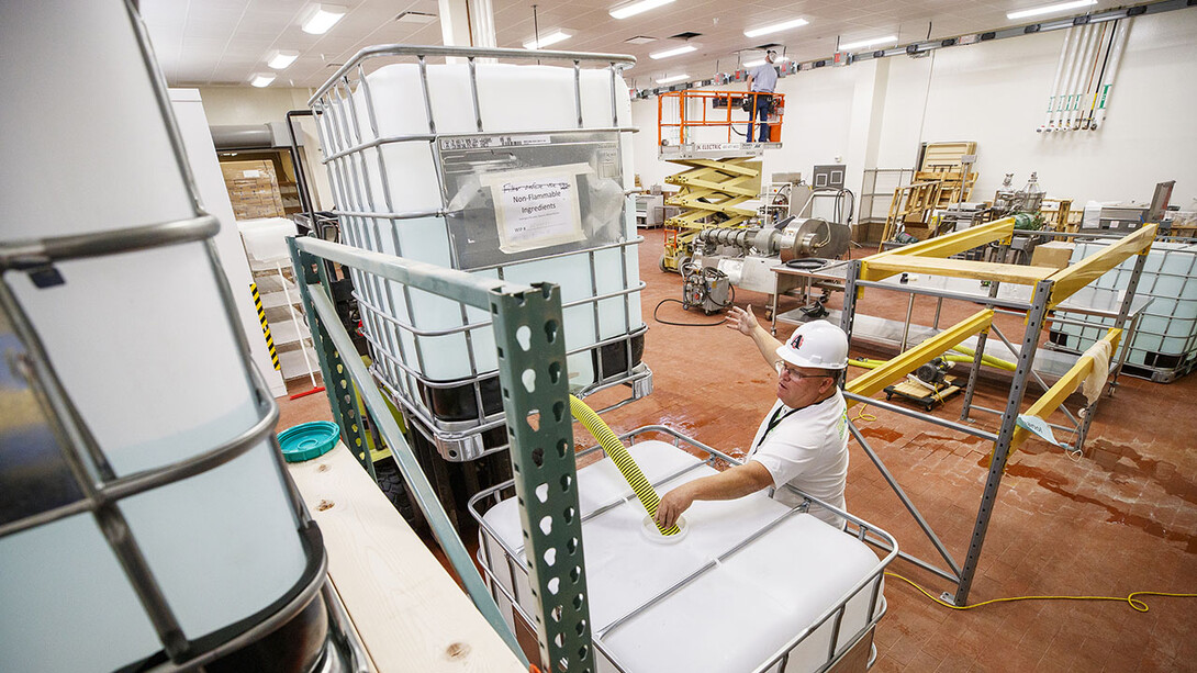 Jan tenBensel, chairman of the Nebraska Ethanol Board, directs Russell Parde as nonflammable ingredients are mixed inside the Food Innovation Center. The ingredients are mixed with the ethanol under stringent safety rules. Hand sanitizer is being made at Nebraska Innovation Campus through a collaboration between the Nebraska ethanol industry and the University of Nebraska–Lincoln.