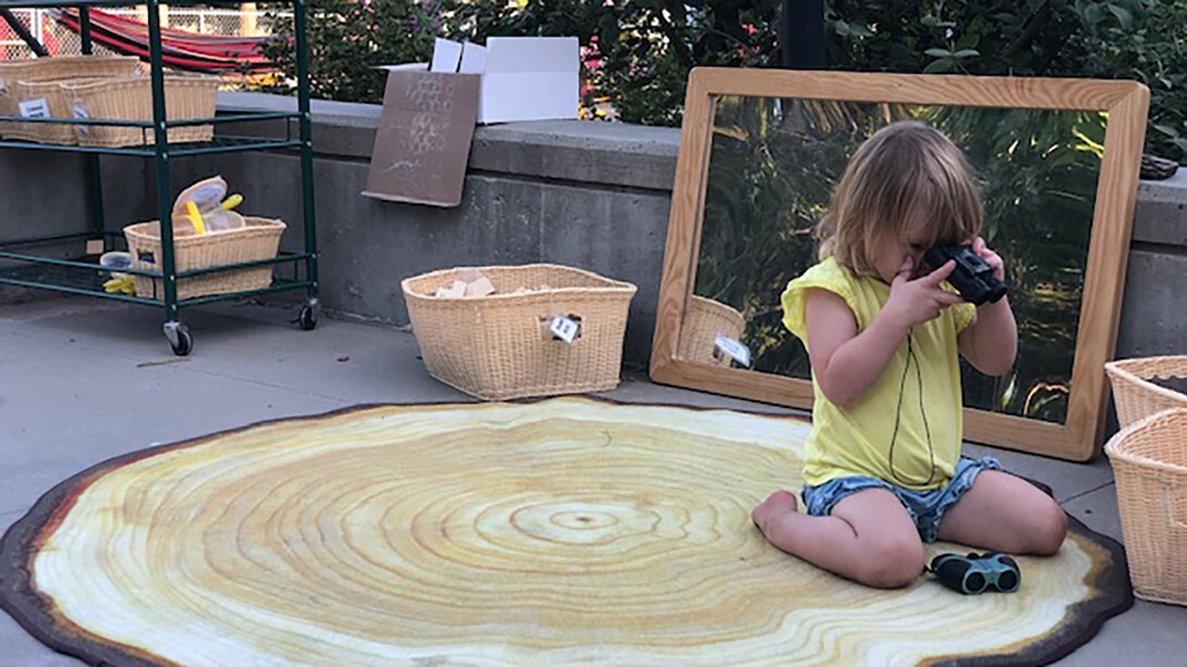 A child plays with binoculars at the Ruth Staples Child Development Laboratory, where outdoor learning is the norm.