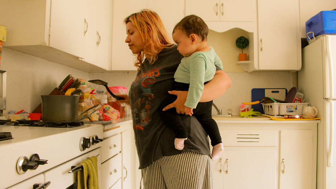 In this photo from Luci Moran’s essay “The Nature of Motherhood,” Sam Vargas prepares lunch for her children while carrying her daughter. “After you have your baby, the hospital will give you a doctor that will tell you, ‘You can call me if you need anything at all, here’s my number,’ and that’s pretty much all you get,” Vargas said. “I remember with my second child, for a moment I felt like I needed help, but I never reached out. It felt like a phone call just wasn’t enoug