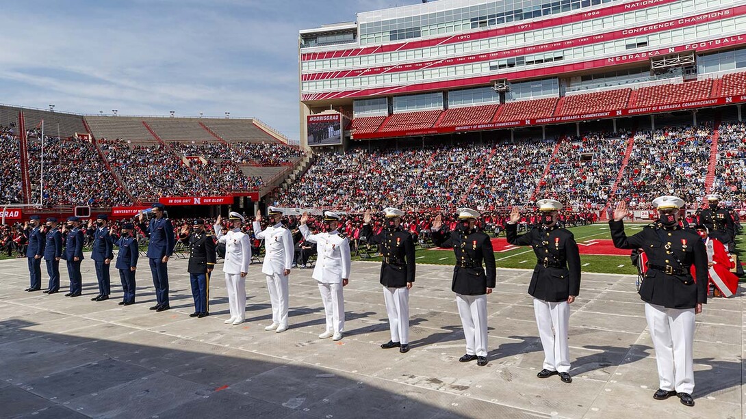 Air Force, Army and Naval ROTC members recite the oath of enlistment during the morning undergraduate commencement ceremony May 8 at Memorial Stadium. Some then changed into regalia to graduate with their colleges.