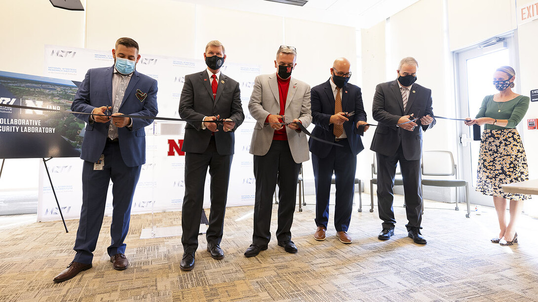 (From left) Joshua Santarpia, NSRI research director; NU President Ted Carter; University of Nebraska–Lincoln Chancellor Ronnie Green; and retired Maj. Gen. Richard Evans, NSRI executive director, cut a ribbon held by Cara Pesek, communications director for IANR Media, during the Sept. 27 opening event for the Collaborative Biosecurity Laboratory.