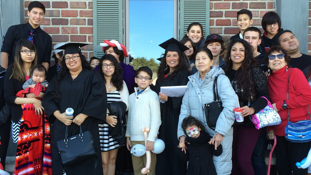 Two graduates of the Indigenous ROOTS Teacher Education Program gather with their families. A new grant will allow the program to expand its efforts and focus on training Indigenous school principals and administrators.