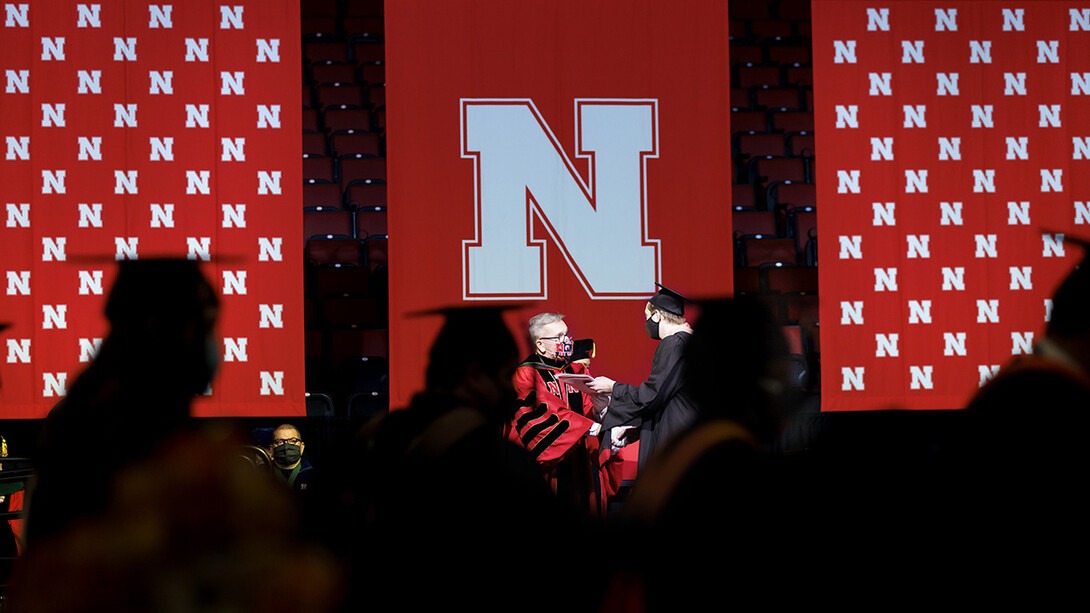 Chancellor Ronnie Green hands a diploma to a graduate during the graduate and professional degree ceremony Dec. 17 at Pinnacle Bank Arena.