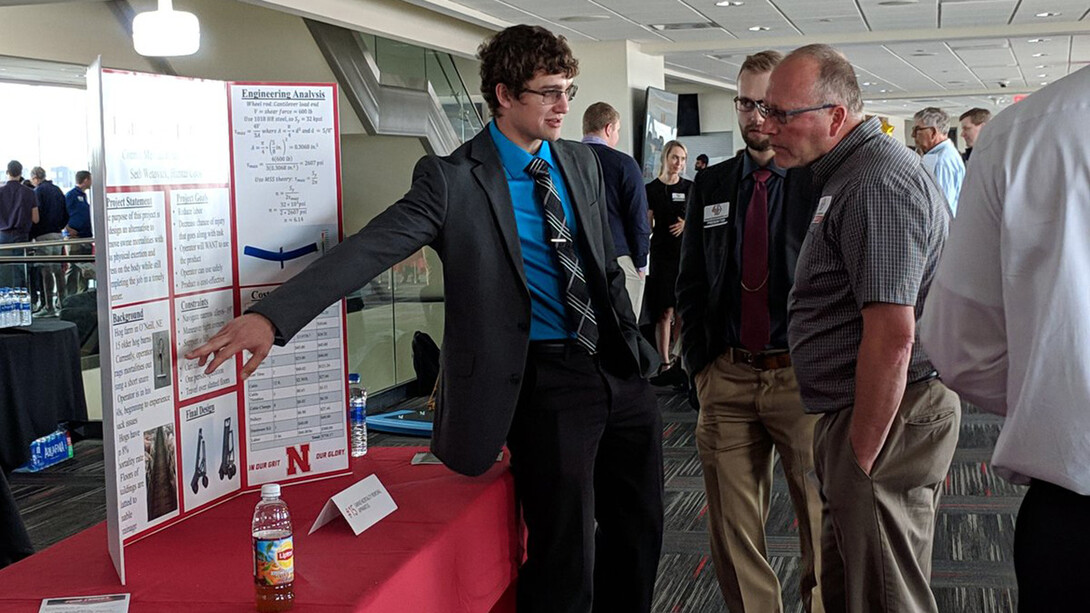 Male student presents poster at previous Senior Design Showcase