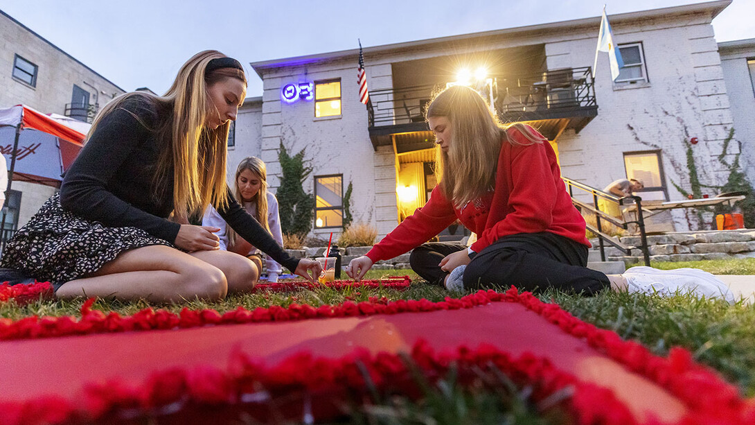 Three members of Chi Omega sorority work on a lawn display outside the Theta Xi fraternity for the 2021 homecoming week. Lawn displays for 2022 will be completed and judged Sept. 30.