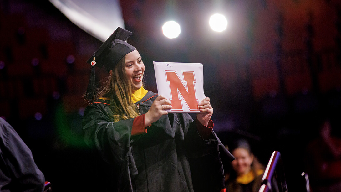 Chloe Christensen celebrates her new degree as she walks off stage during the University of Nebraska–Lincoln's graduate and professional degree ceremony Dec. 16 at Pinnacle Bank Arena. She earned a Master of Science in food science and technology.