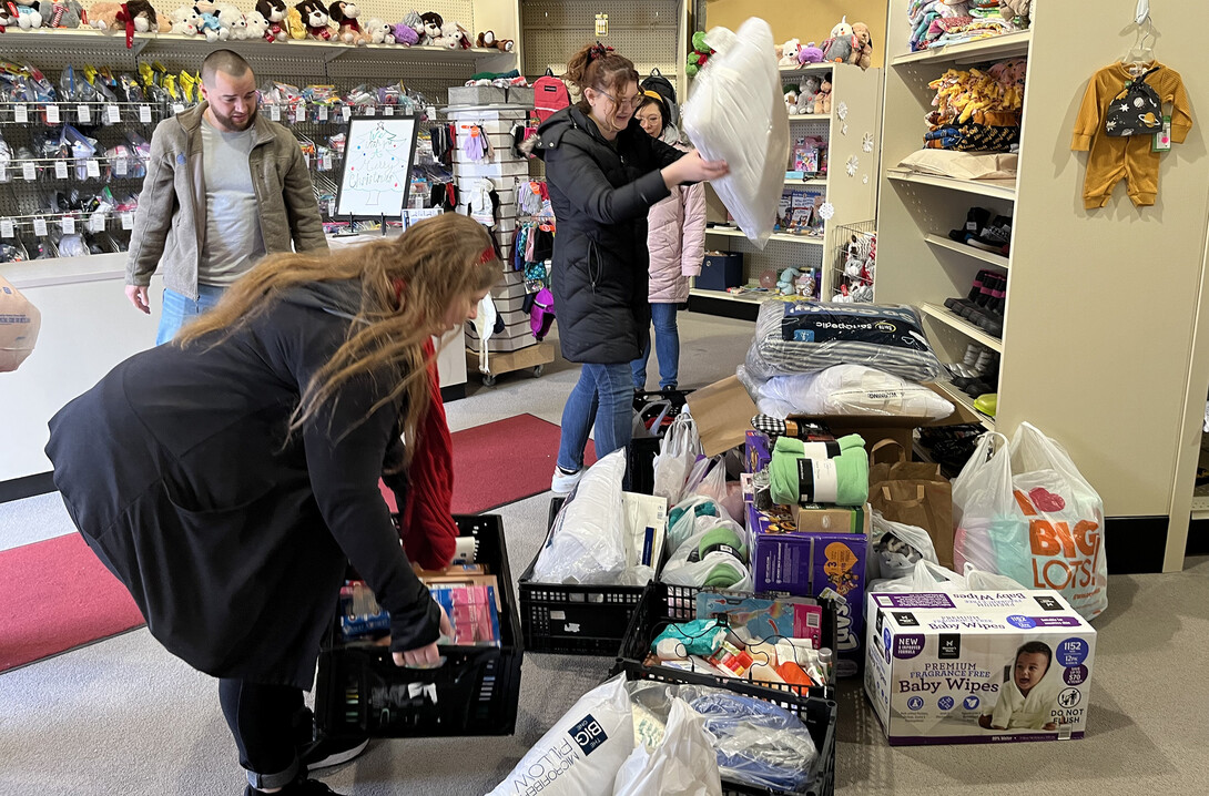 Megan Thomazin (left) and Ellyn McCarter (center) stack up donations at the Foster Care Closet.