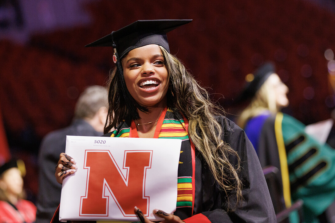 Bouthaina Ibrahim smiles to family and friends after receiving her Bachelor of Journalism during the undergraduate commencement ceremony.