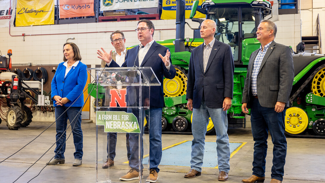 Congressman Mike Flood talks at the podium in the Tractor Test Lab facility on East Campus.