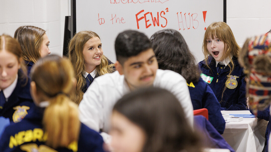 Nebraska FFA members sit at tables.