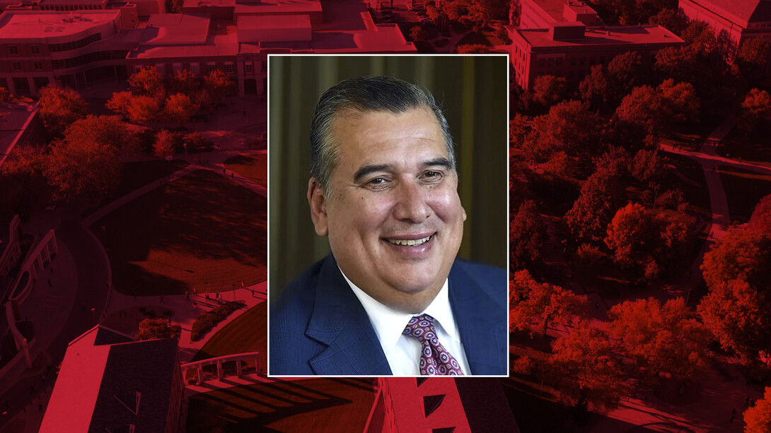 Color portrait of Bill Johnson on red campus background