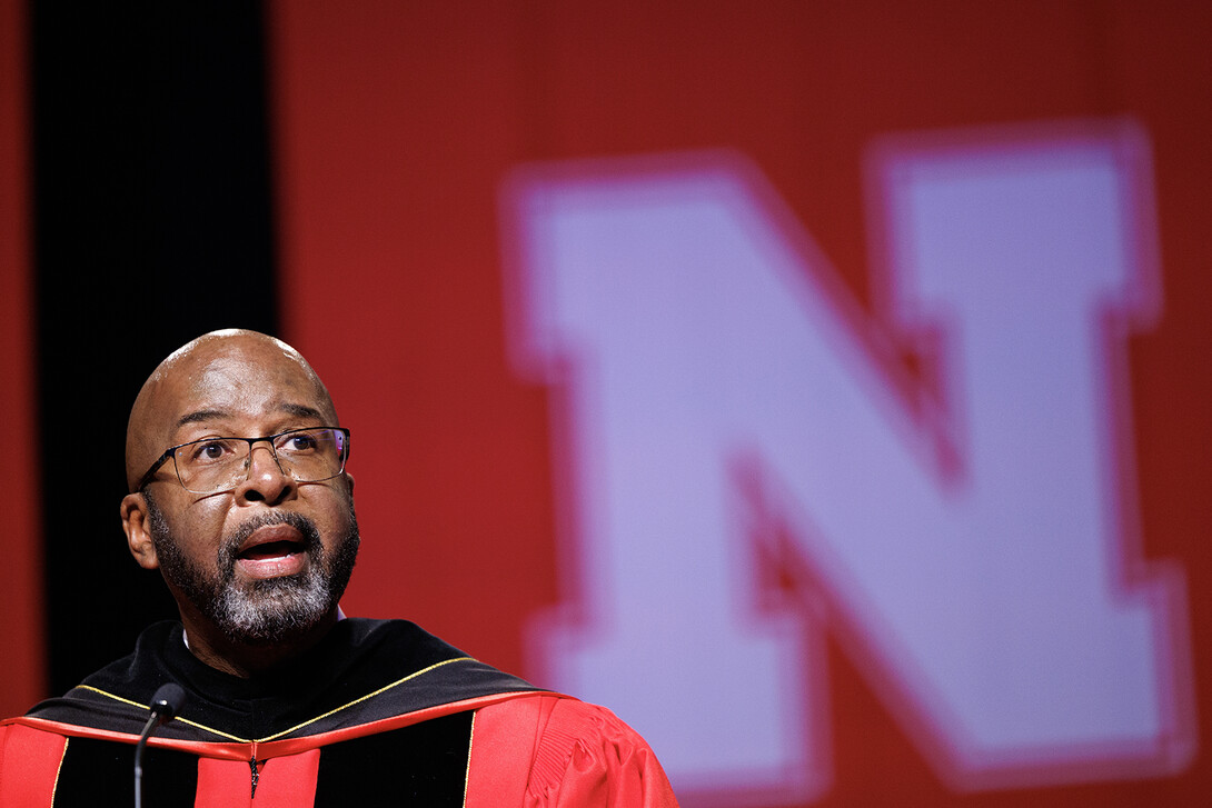 Chancellor Rodney Bennett speaks in front of a white Nebraska N.