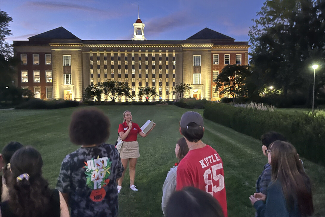 Emmerson Putnam tells a group of students about Love Library, its accompanying gardens, and the Dunkin' Donuts in the Adele Hall Learning Commons.