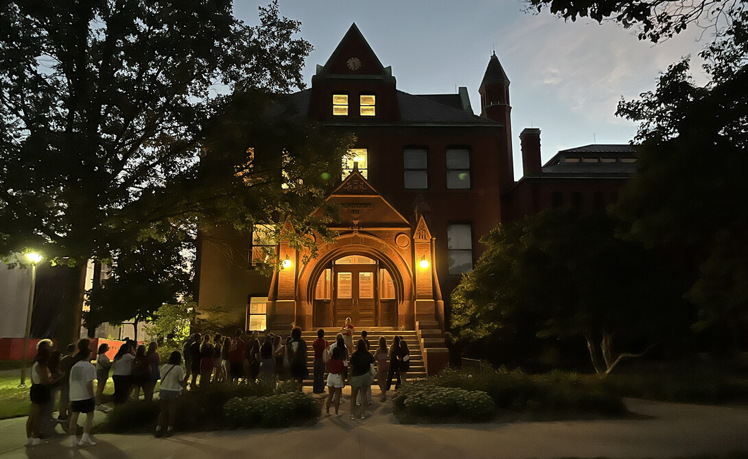 A group of students gathers at Architecture Hall to learn some of the history of the oldest building on campus.