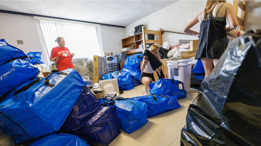 Alyssa Hurlock of Apple Valley, Minnesota, watches as Lily Hurlock unpacks her belongings in the Smith Residence Hall room she shares with her sister, Haven. The two are sharing a room, while their triplet sister Montanna has a room on another floor in the hall.