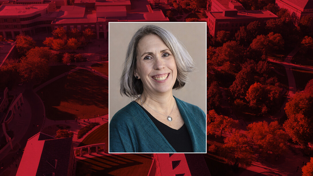 Color portrait of Deborah Bathke on red campus background