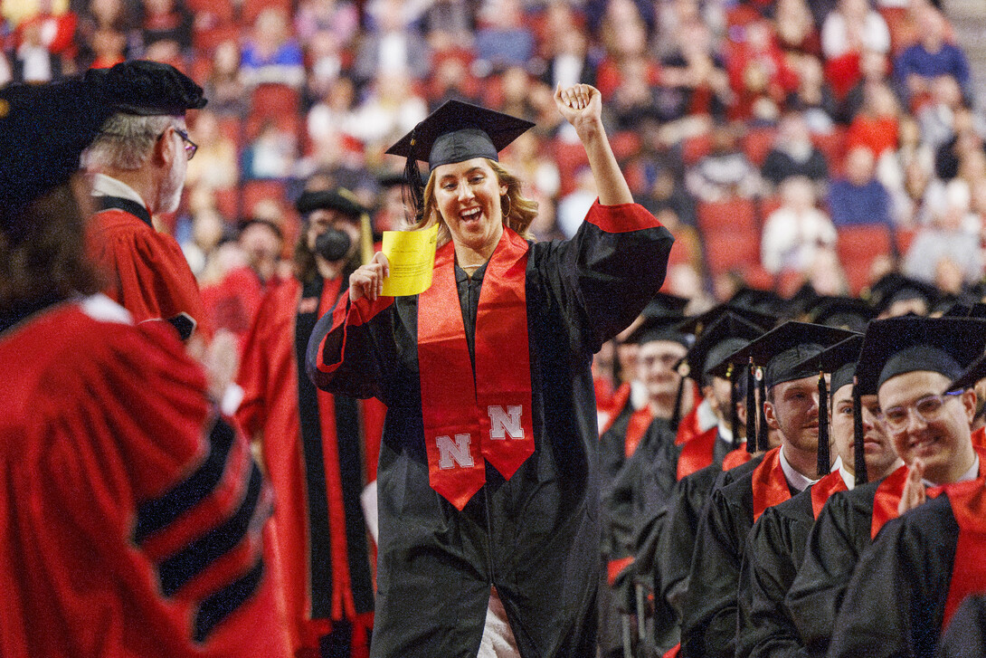 Graduate Stella Lepkowski skips down the aisle at commencement.