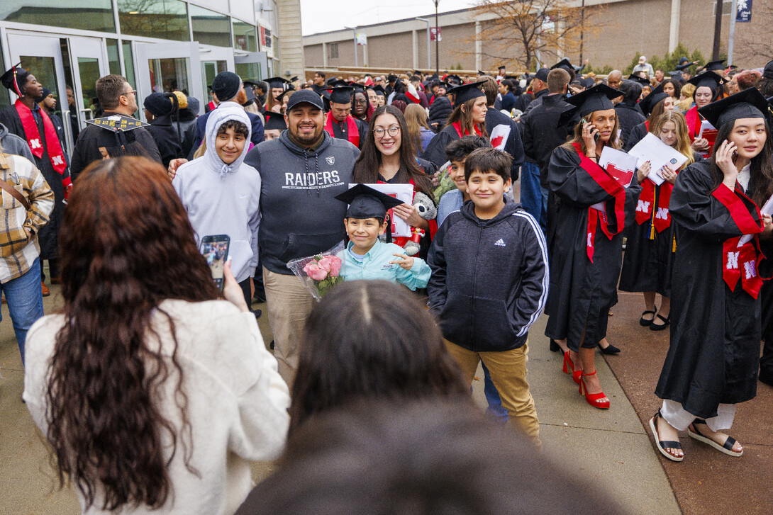 Graduate Ruby Garcia Gonzalez takes pictures with family and friends outside Pinnacle Bank Arena.