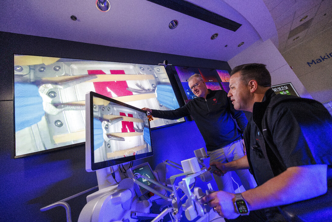 Nebraska Engineering professor and Virtual Incision co-founder Shane Farritor watches as Dr. Michael Jobst uses surgical controls in front of two video screens.