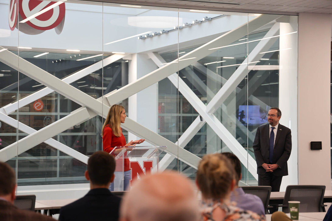 Jill O'Donnell stands at a podium to introduce John Bass, under secretary of state for political affairs.