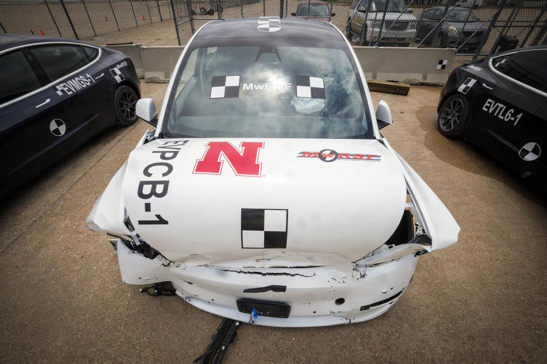 A white Tesla crash test car with a smashed front end