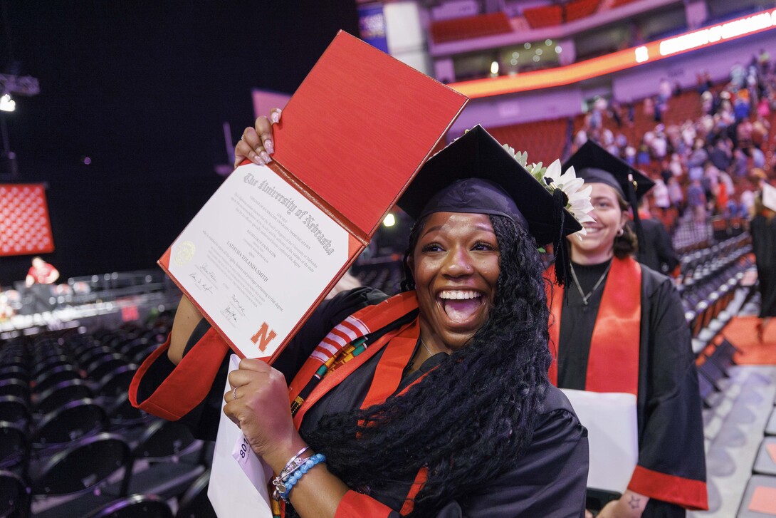 Ladaysia Smith shows off her diploma to family and friends.