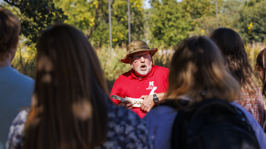 Dave Wedin, director of the Center for Grassland Studies and professor in the School of Natural Resources, holds an animal jaw bone while speaking to a group of Husker students.