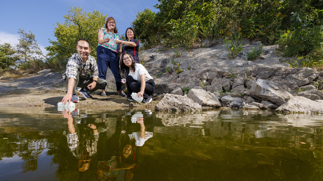 Xu Li (front left), Bing Wang (front right), Shannon Bartelt-Hunt (back left) and Yusong Li (back right) collect and examine water samples from the Elkhorn River near Waterloo, Nebraska.