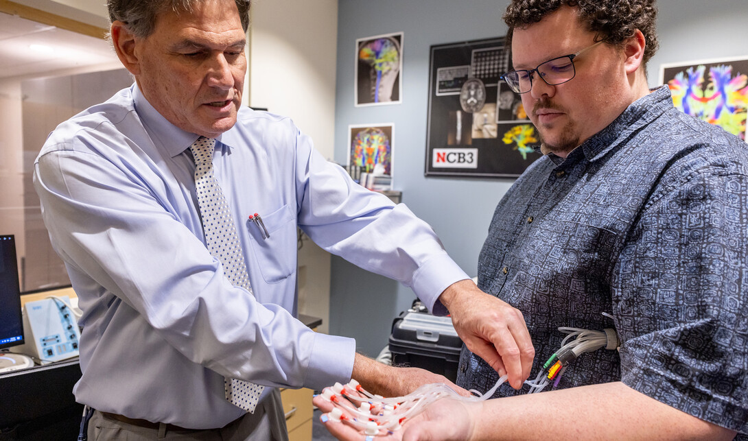 Steven Barlow (left) attaches the pTACS' thermoplastic tactile ‘touch’ capsules to the hand of Jacob Greenwood.