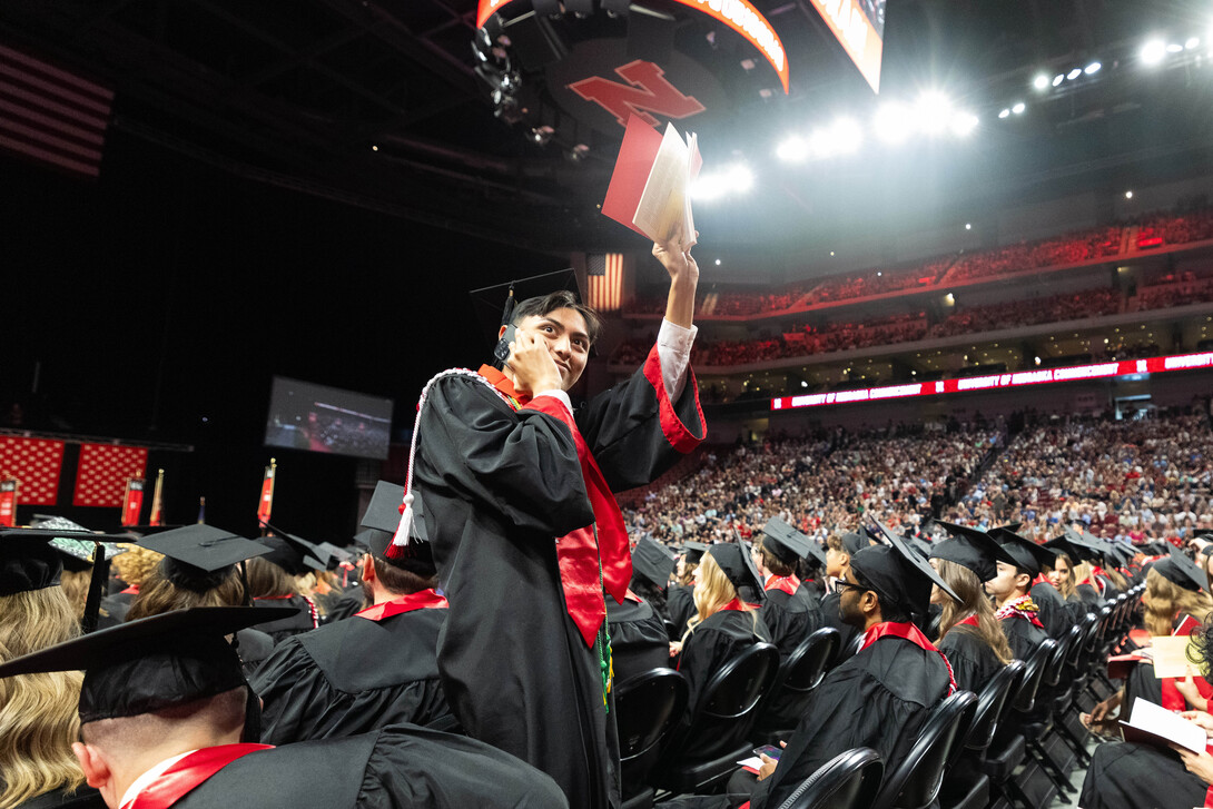 Carlos Tavira-Villegas waves to his family during the afternoon undergraduate commencement ceremony.