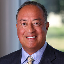 Color portrait of Ken Moreano, CEO of Scott Data, wearing a suit and tie.