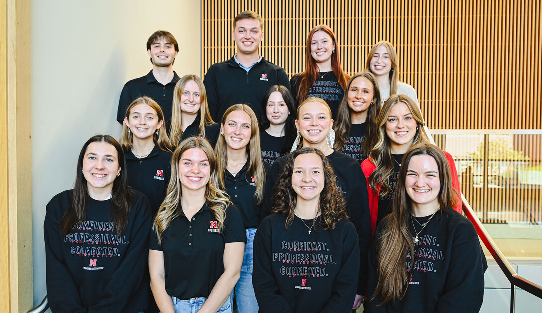 Thirteen young women and two young men — all peer career coaches in the University of Nebraska–Lincoln's College of Business, pose for a group photo on a staircase.