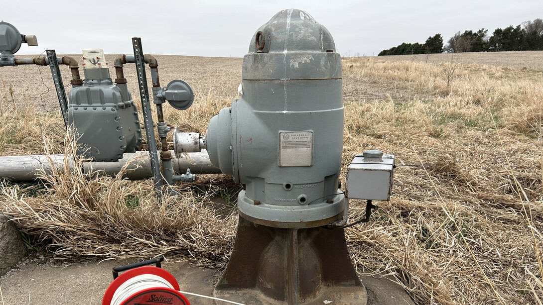 A well measuring tape is positioned next to an irrigation well head in preparation for making a water level measurement.