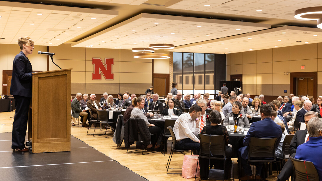 Tiffany Heng-Moss, Harlan Vice Chancellor for the Institute of Agriculture and Natural Resources at the University of Nebraska–Lincoln and vice president for agriculture and natural resources for the University of Nebraska system, speaks at a lectern in a crowded conference room in the Nebraska East Union.